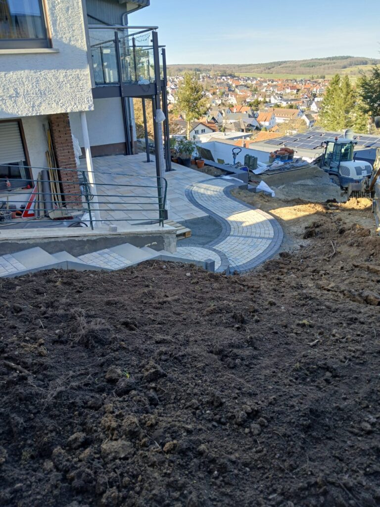 Hanggarten mit geschwungenem Weg und vorbereiteter Rasenfläche